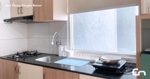a kitchen with a sink and a window at Jarrdin Apartment by CozyNest Syariah in Bandung