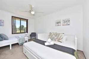 ein Schlafzimmer mit zwei Betten und einem Deckenventilator in der Unterkunft Helena Grand Estate Hunter Valley in Ellalong + 31 Fotos