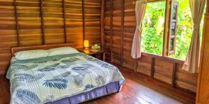 a bedroom with a bed and a window at Affordable shack in Ko Yao Noi