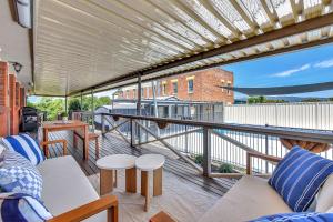 ein Balkon mit Sofas und Tischen auf einem Gebäude in der Unterkunft Helena Grand Estate Hunter Valley in Ellalong