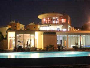 a building with a pool in front of it at night at Noiva do Mar in Lourinhã