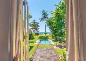 丹戎Hotel Tugu Lombok的从窗户可欣赏到游泳池的景色