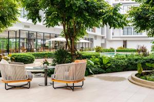 two chairs and a table in a courtyard with a building at Laya Resort -Tropical Studio in Layan Beach