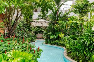 a swimming pool in a garden with trees and plants at Laya Resort -Tropical Studio in Layan Beach