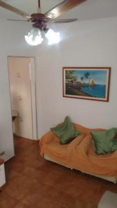 a living room with a couch and a ceiling fan at O AP DO FÊ - Apartamento Praia Grande - Vila Tupi in Praia Grande