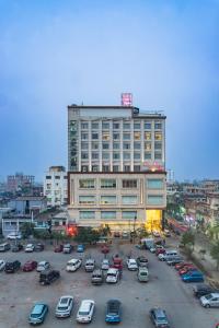 a large building with cars parked in a parking lot at Siddhartha Diyalo in Bīrganj