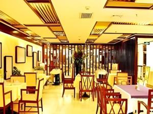 ein Esszimmer mit Tischen und Stühlen und Tischplatte in der Unterkunft Lijiang Waika Hotel in Lijiang