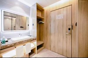 un baño con lavabo y espejo en Qingdao Likelai Garden Hotel, en Qingdao 36 fotos más