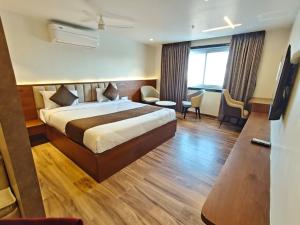 a hotel room with a bed and a living room at Ricch Hotels in Hyderabad