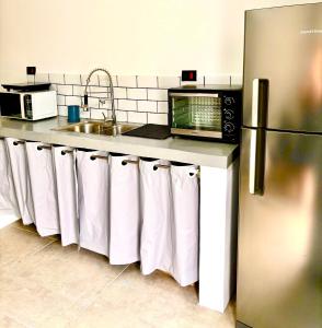 een keuken met een wastafel en een aanrecht met witte handdoeken bij Refúgio Urbano in Jacareí +4 foto's