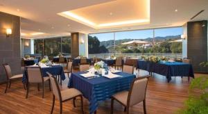 ein Restaurant mit blauen Tischen und Stühlen mit Aussicht in der Unterkunft Takato Sakura Hotel in Ina