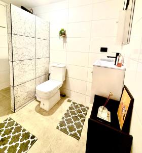 een badkamer met een wit toilet en een wastafel bij Refúgio Urbano in Jacareí