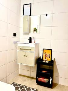 een badkamer met een witte kast en een spiegel bij Refúgio Urbano in Jacareí