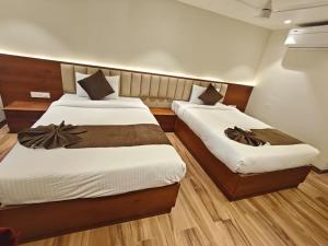 two beds in a small room with at Ricch Hotels in Hyderabad +7 photos