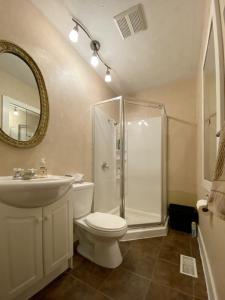 a bathroom with a shower and a toilet and a sink at Spacious & Practical 4 Bed Home in Sudbury +18 photos