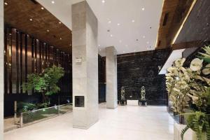 eine Lobby mit zwei Personen, die auf Stühlen in einem Gebäude sitzen in der Unterkunft ZIXIN FOUR SEASONS HOTEL in Gutang