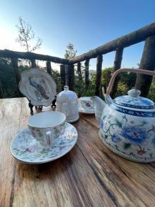 un service à thé sur une table en bois avec une théière dans l'établissement Lee's Grandma's Will Cottage, à Kalimpong