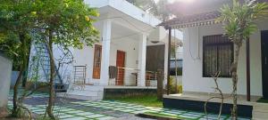 a white house with a porch and stairs to it at Munroe Heritage Inn in Munroe Island
