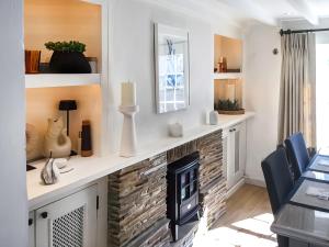 a living room with a fireplace and a table and chairs at Shearwaters in Saint Mawes
