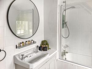 a white bathroom with a sink and a mirror at Shearwaters in Saint Mawes +10 photos