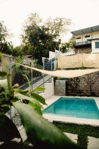 a swimming pool with a hammock above it at Villa Palmarcito in El Zonte +22 photos
