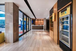 einen Flur eines Ladens mit offenem Kühlschrank in der Unterkunft IU Hotel Kunming Jinma Bijifang Joy City in Kunming