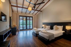 une chambre avec deux lits et une grande fenêtre dans l'établissement Lavendish Beach Resort, à Unawatuna
