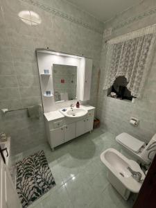 a bathroom with a sink and a toilet and a mirror at Ta Mary Apartment A Perfect St Pauls Bay Base in St Paul's Bay