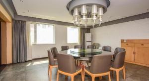 a dining room with a table and chairs and a chandelier at Jinjiang Inn Style Shijiazhuang Zhongshan Xi Road Yuxi Park in Shijiazhuang