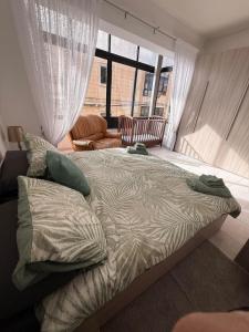 a large bed in a bedroom with a large window at Ta Mary Apartment A Perfect St Pauls Bay Base in St Paul's Bay