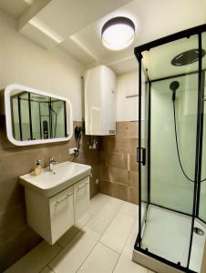 une salle de bain avec un lavabo et une douche en verre dans l'établissement Modern Old Town Studio, à Hall en Tirol