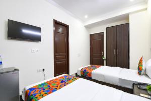 古尔冈Hotel Springbok的一间卧室，配有两张床和一台平板电视