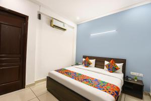 古尔冈Hotel Springbok的卧室里有一张床，上面铺着一条彩色毯子