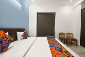 古尔冈Hotel Springbok的一间卧室，里面有一张床、一张桌子和几把椅子。