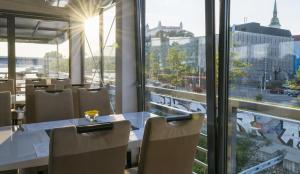 a restaurant with a table and chairs and a large window at Botel Gracia in Bratislava