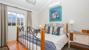 ein Schlafzimmer mit Bett, Schreibtisch und Fenster in der Unterkunft Seven Oaks Vineyard Cottages in Wolseley