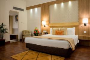 a bedroom with a large bed in a hotel room at Hotel The Tulip international Near Delhi Airport,A block Road no 4 street no 10 mahipalpur new delhi in New Delhi +4 photos