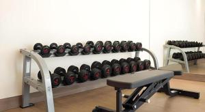 a gym with a rack of dumbbells on a wall at B2 Amata Nakorn Premier Hotel in Ban Chak Samo