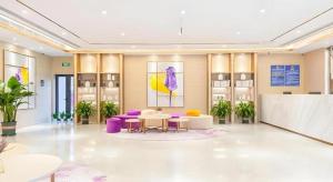 a lobby with purple and white furniture in a building at Lavande Hotel Beijing Fangshan Changyang Metro Station in Pei-kang-wa