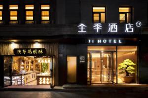 un negozio di fronte a un hotel di notte di Ji Hotel Beijing qianmeng dian 全季北京前门地铁站酒店 a Pechino