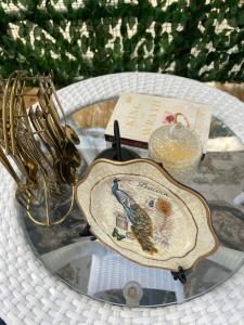 une table en verre avec une assiette ornée d'un oiseau. dans l'établissement Lee's Grandma's Will Cottage, à Kalimpong