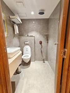 a bathroom with a toilet and a sink and a shower at Ricch Hotels in Hyderabad