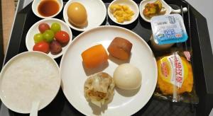 ein Tablett mit einem Teller mit Obst und Gemüse in der Unterkunft Green Tree Inn Express Shanghai Bund Yuyuan Xiaonanmen Metro Station in Shanghai