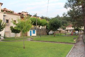 a garden with a playground in front of a building at Casa do Rio - Penacova in Raiva