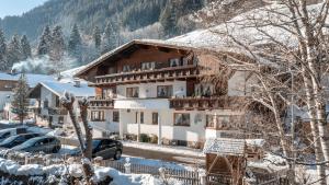 a snow covered building with cars parked in front of it at Apart Fortuna in See