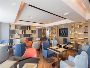 ein Restaurant mit Tischen, Stühlen und Bücherregalen in der Unterkunft Echarm Hotel Changsha Xiangya Fushan in Changsha