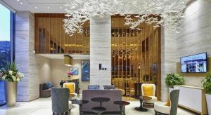 a hotel lobby with tables and chairs and a chandelier at City Comfort Inn Tonglu Fuchun River Qiaolin Road in Tonglu