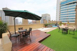 a wooden deck with a table and chairs and an umbrella at Xingtai Yuehai Hotel in Haikou