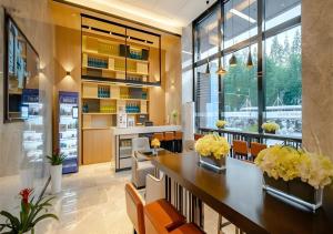 a dining room with a table with yellow flowers on it at Echarm Hotel Hefei West Qilitang Metro Station in Hefei