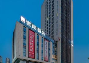 a group of tall buildings with signs on them at Echarm Hotel Hefei West Qilitang Metro Station in Hefei